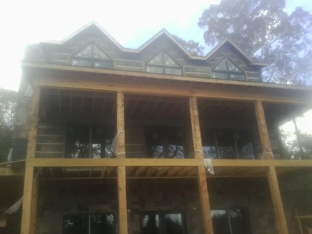 Dormers and porch framing on a large log home under construction — Roof Coating work by our crew in Sunnyvale