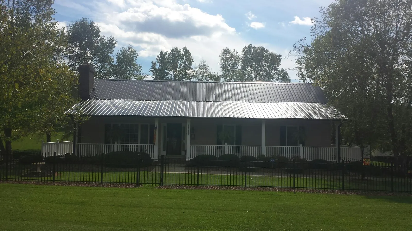 Gray metal roof on a brick ranch with a full width front porch — Gutter Guard Installation work by our crew in Sunnyvale