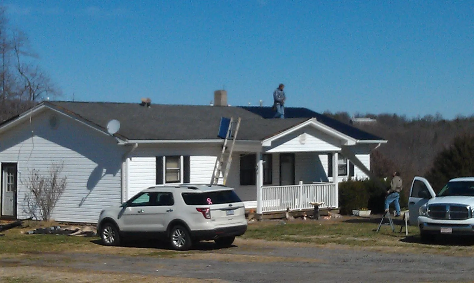 Roofers stripping shingles from a white ranch house roof in Sunnyvale